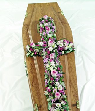 Loose pink and white funeral cross including roses, carnation and lizianthus. 