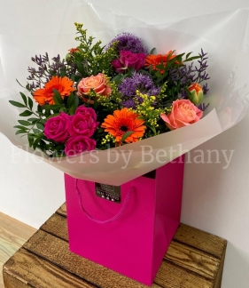 Spring bouquet filled with citrus toned florals including rose, spray rose, germini and solidago. Hand tied in water and presented in our signature bag and cellophane wrap. 