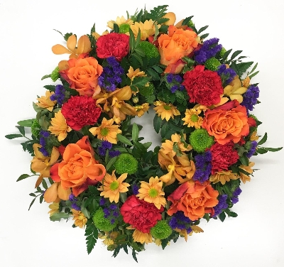 Loose wreath in the perfect sunset colours, including roses, orchids and carnation. 