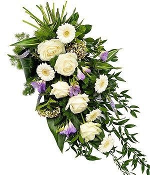 Lilac and white flat spray funeral tribute including roses, germini and freesia.