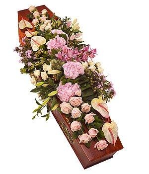 Luxury pink casket spray including anthuriums, orchids, roses and mixed foliage. 
