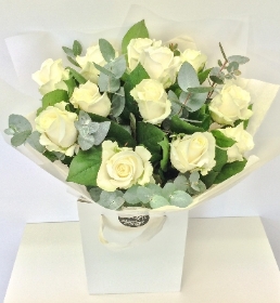 Hand tied bouquet of white roses and scented eucalyptus. 