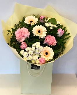 Gorgeous hand tied bouquet including germini, carnation, tulips and chrysanthemums in an array of warm pastel colours. 