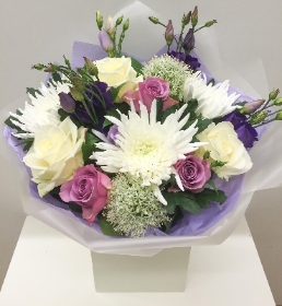 Hand tied bouquet of lilac, white and purple flowers. Including roses, lisianthus and blooms. 