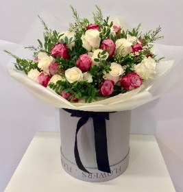Luxury gift bouquet of lilac and white roses, touches of scented wax flower and presented in a grey hatbox. 