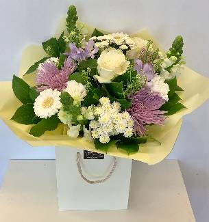Soft cream and lilac bouquet including blooms, roses and freesia. 
