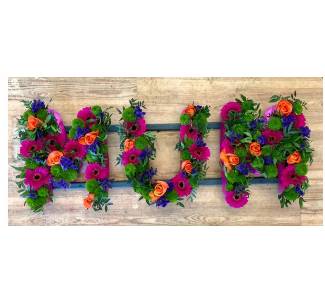 Stunning vibrant mixed letter MUM funeral tribute including roses, germini, orchids and chrysanthemum mix. 