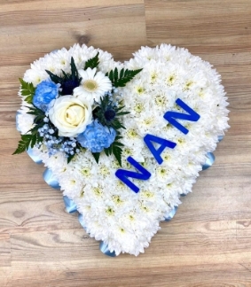 Heart funeral tribute with light blue ribbon and focal with NAN wording laminated on the front. 