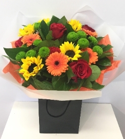 Bouquet including a mix of fiery colours with roses, germini and sunflowers. 