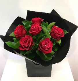 Simply 6 x luxury red roses and foliage presented in matching cello and bag. 