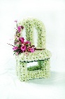 Vacant chair funeral tribute with lovely soft pink focal flowers. 