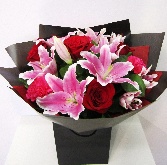 Luxury bouquet including large headed red roses, pink lily and finished with some cerise carnations. 