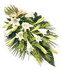 Pure white lily funeral spray with complementary foliage. 